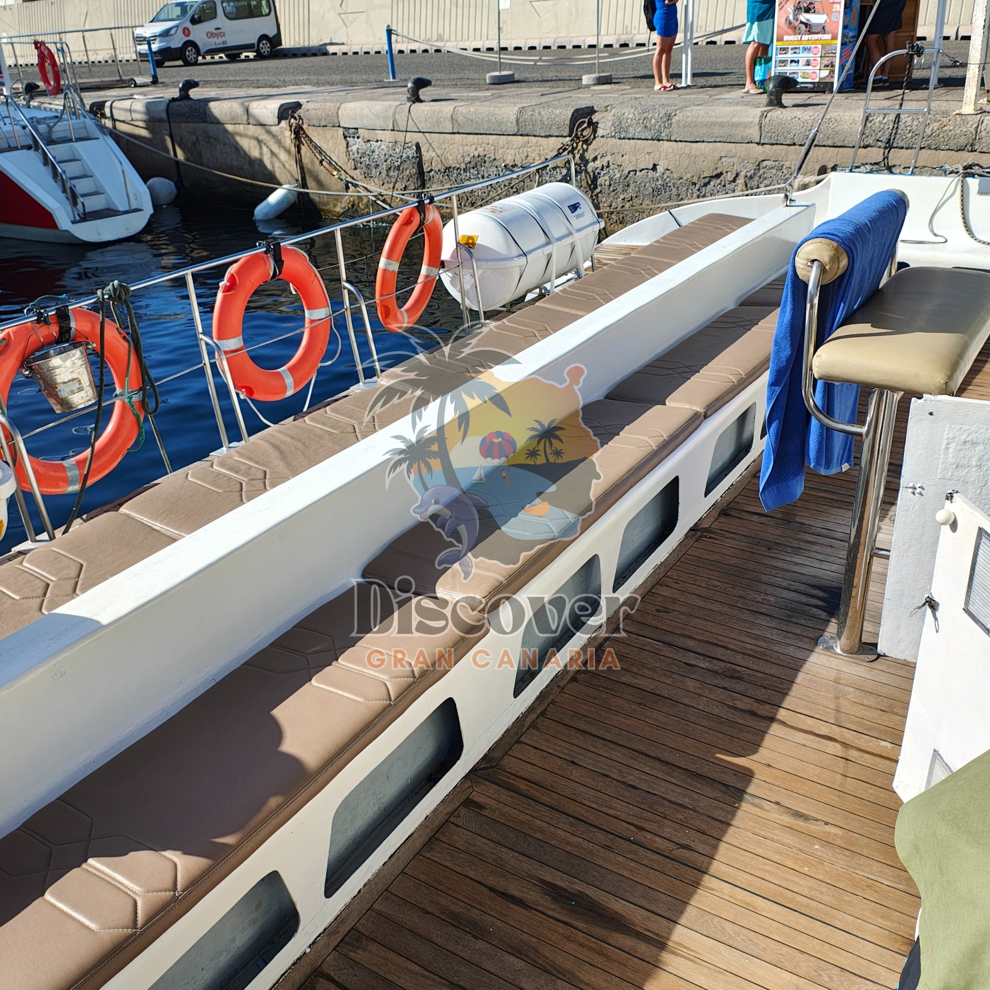 Boat deck with life buoys and a chair, with 'Discover Gran Canaria' branding.