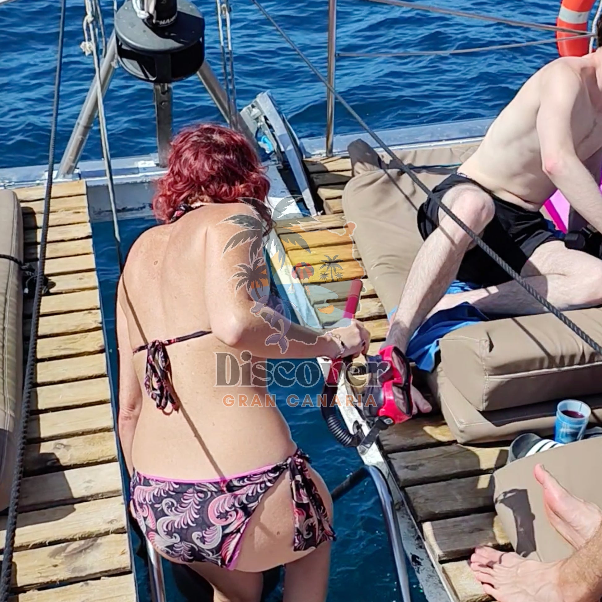 Woman in a bikini on a boat with water in the background