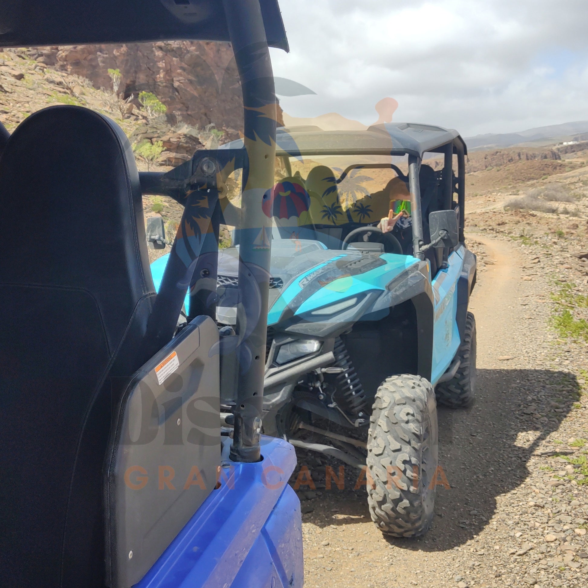 Blue off-road buggy vehicle on a dirt road with a scenic background