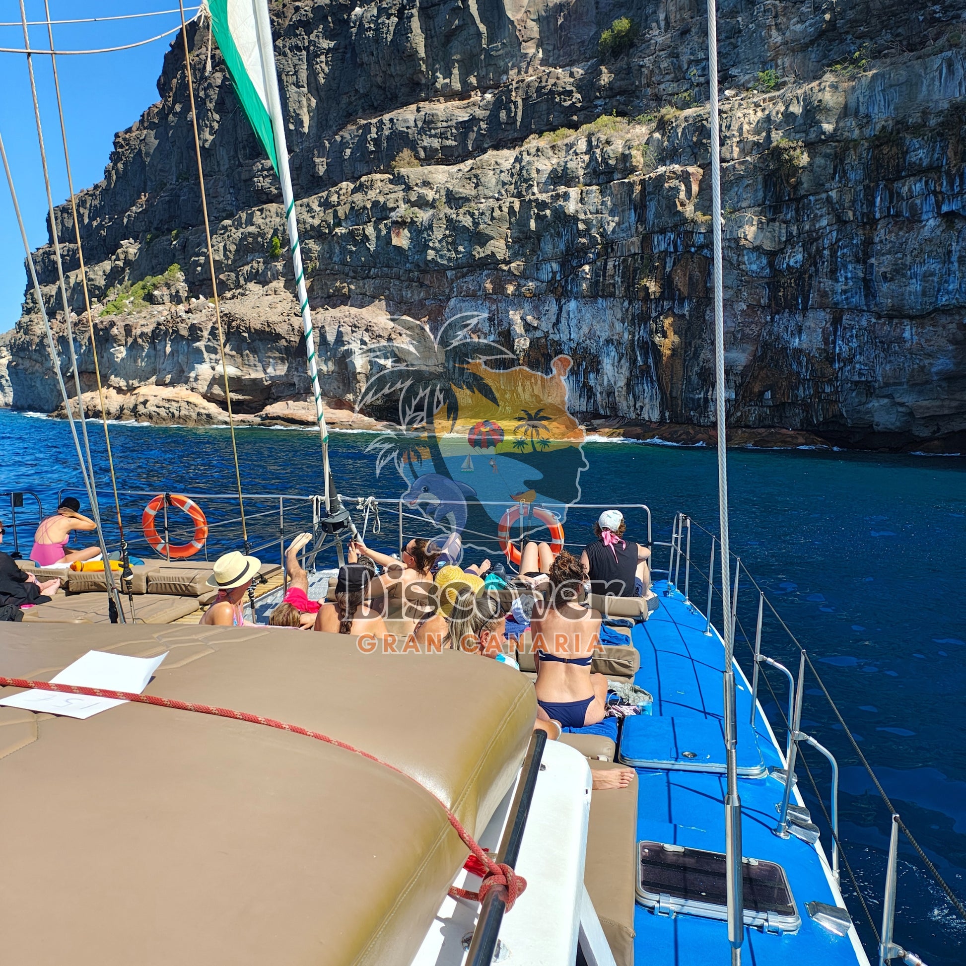 People on a boat in the water with cliffs in the background