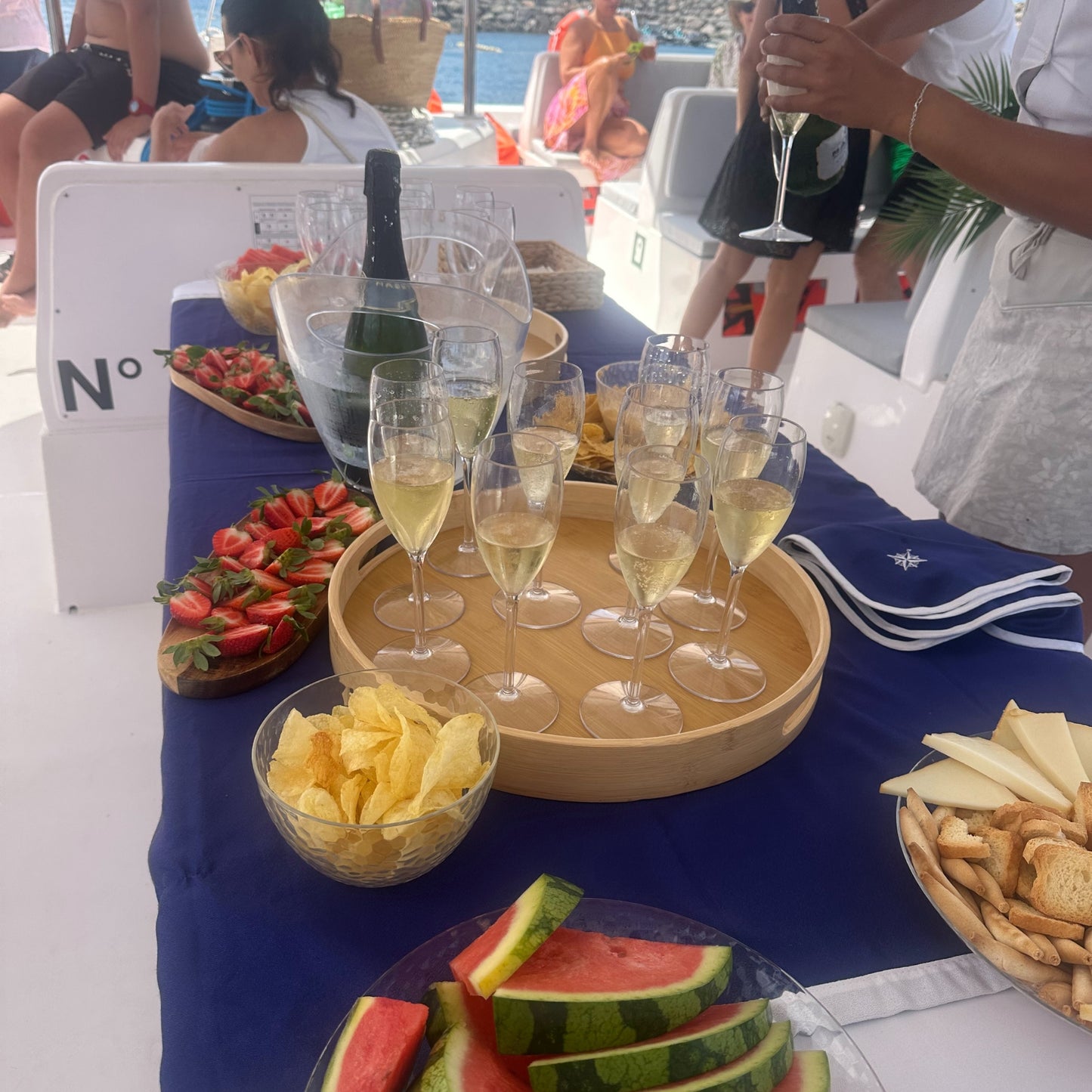 Table with champagne, snacks, and people on the stingray catamaran