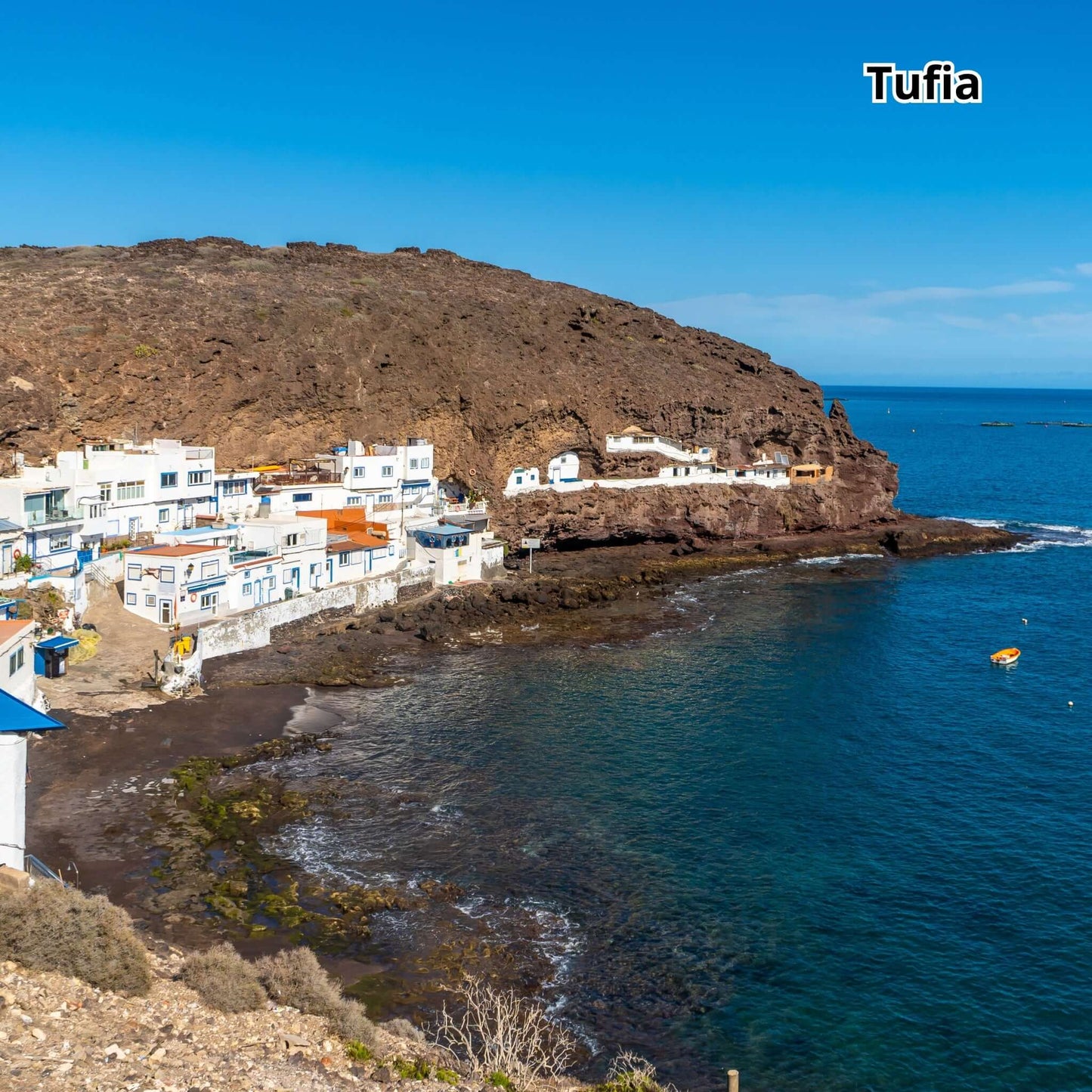 Scenic view of Tufia, Gran Canaria, showcasing coastal houses and clear water.