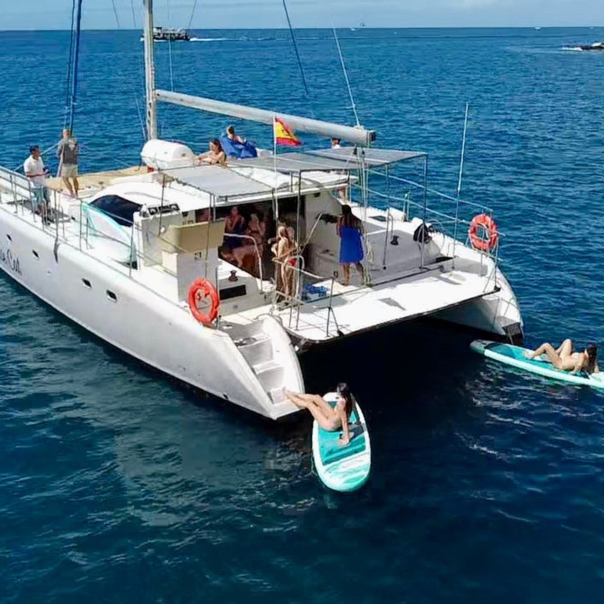 White catamaran with people on a sunny day in the ocean