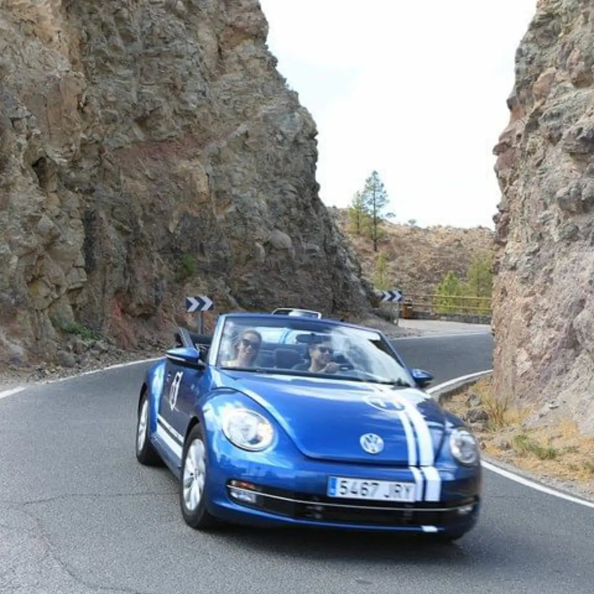 Blue Volkswagen Beetle convertible driving on a mountain road in Fataga, Gran Canaria