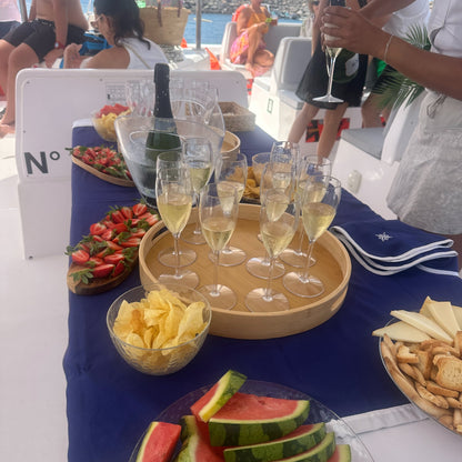 Table with champagne, snacks, and people on the stingray catamaran