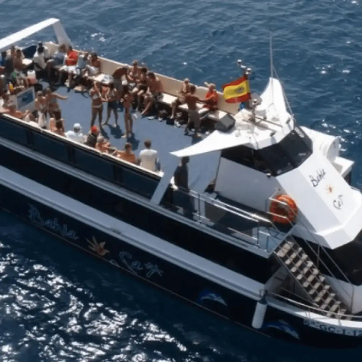Large boat with people dancing during the boat party gran canaria, on a sunny day at sea