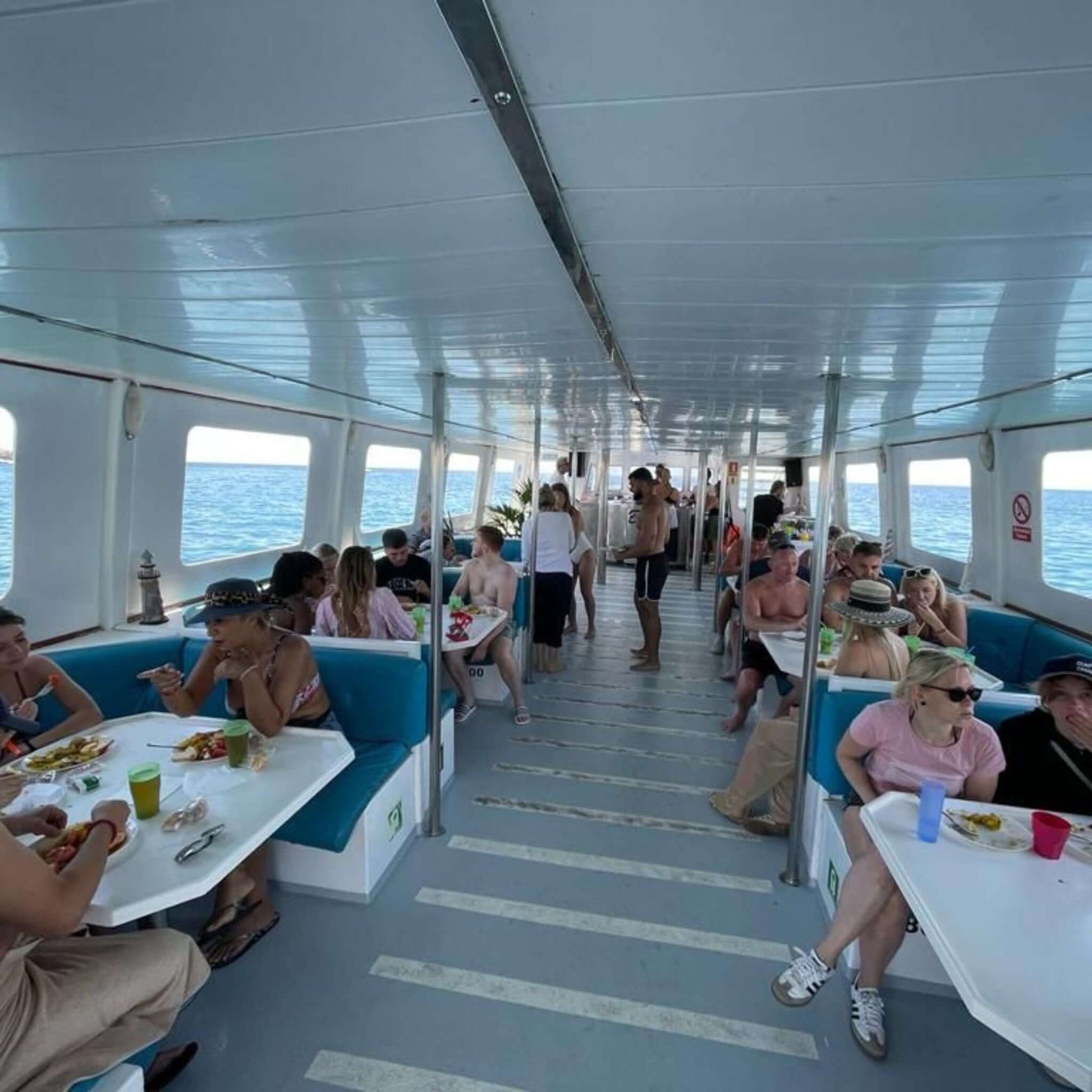 Interior view of the Princesa Ico All Inclusive Boat Trip Gran Canaria, featuring guests enjoying lunch and drinks.