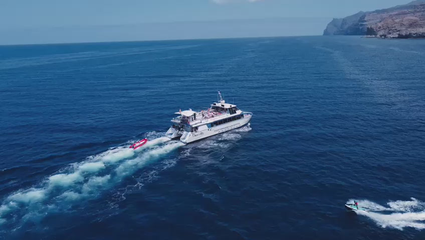 Princesa Ico All Inclusive Boat Trip Gran Canaria sailing on the ocean with a water sport activity beside it.